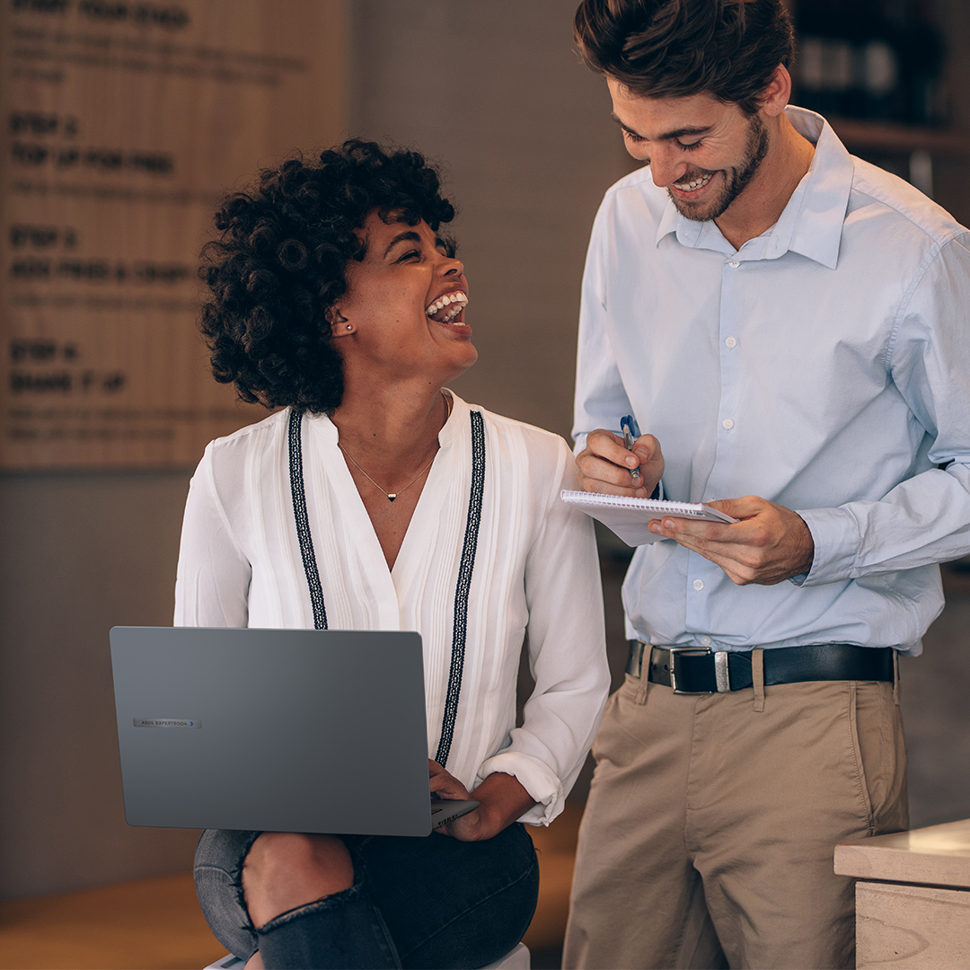 All-around partnership Two empolyees are discussing and laughing together with an ASUS ExpertBook on laps.